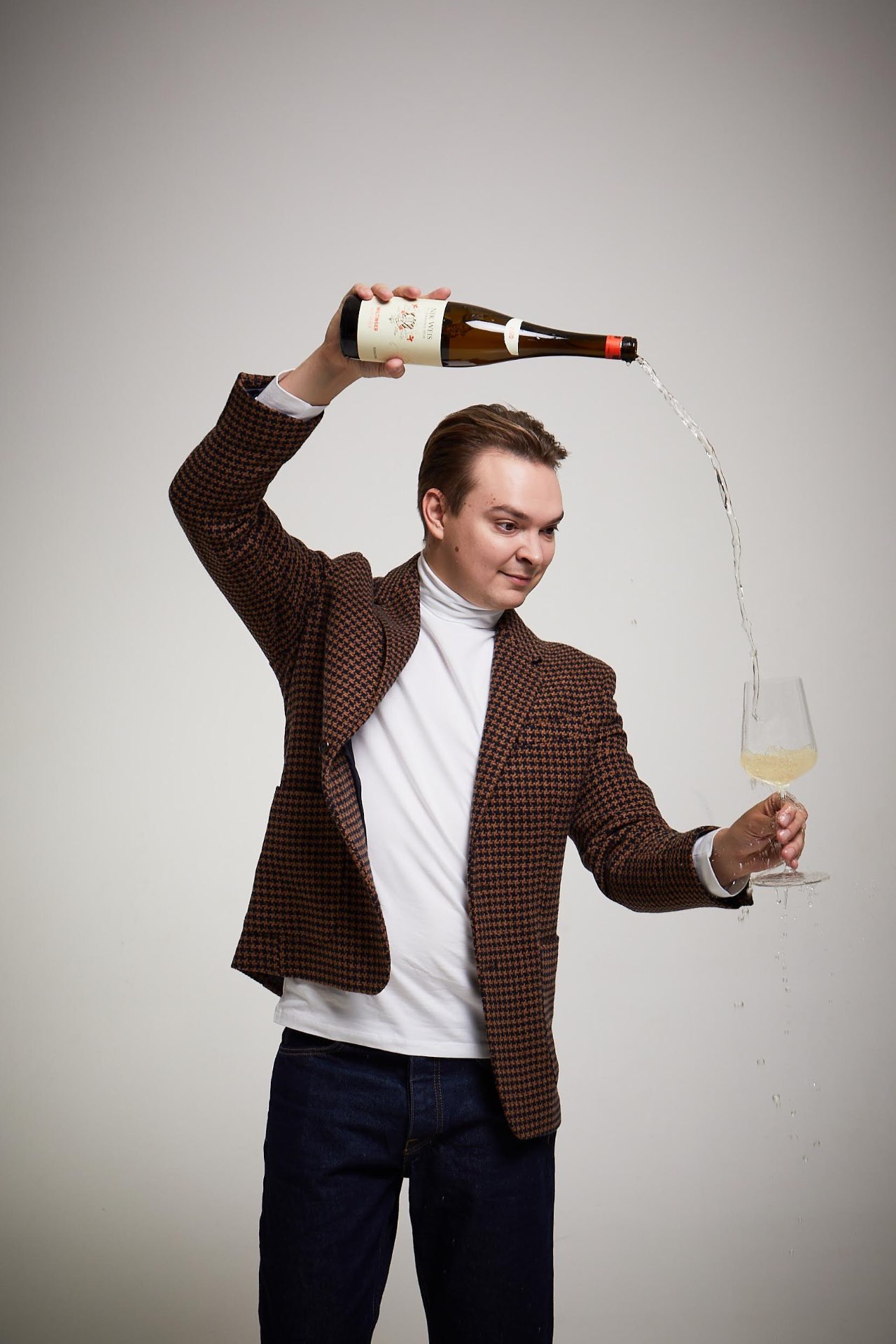 Dmitry Kocheruk pouring white wine into a glass